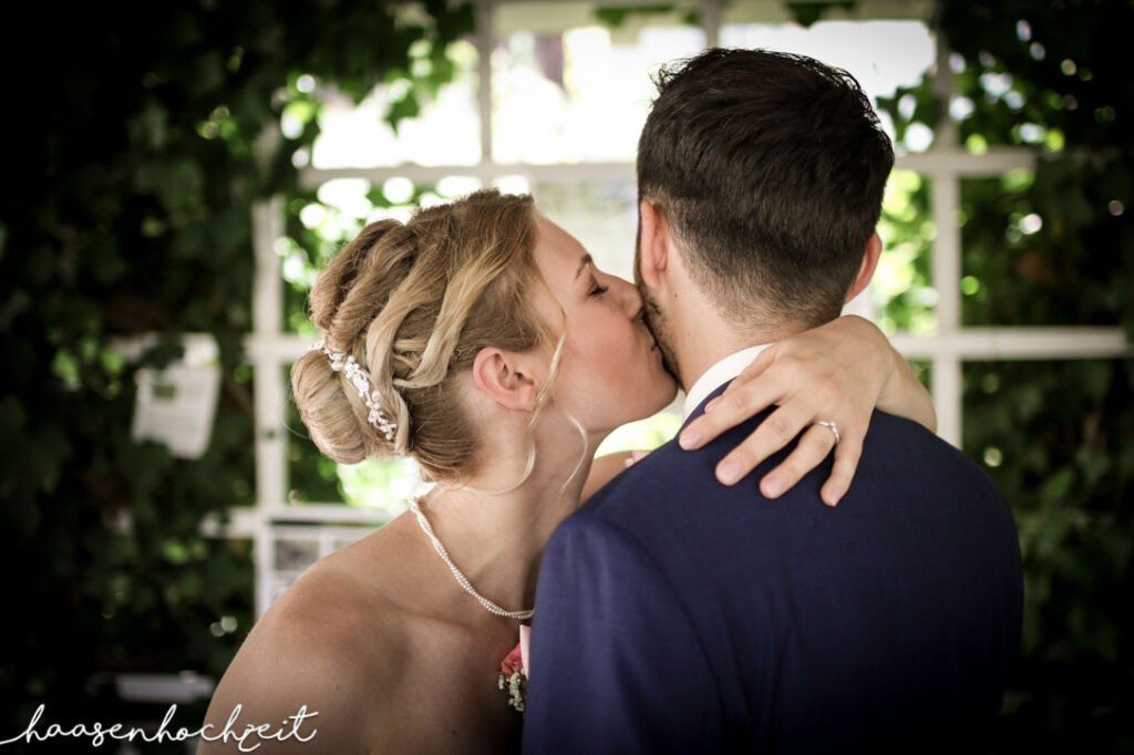 Braut küsst Bräutigam auf die Backe